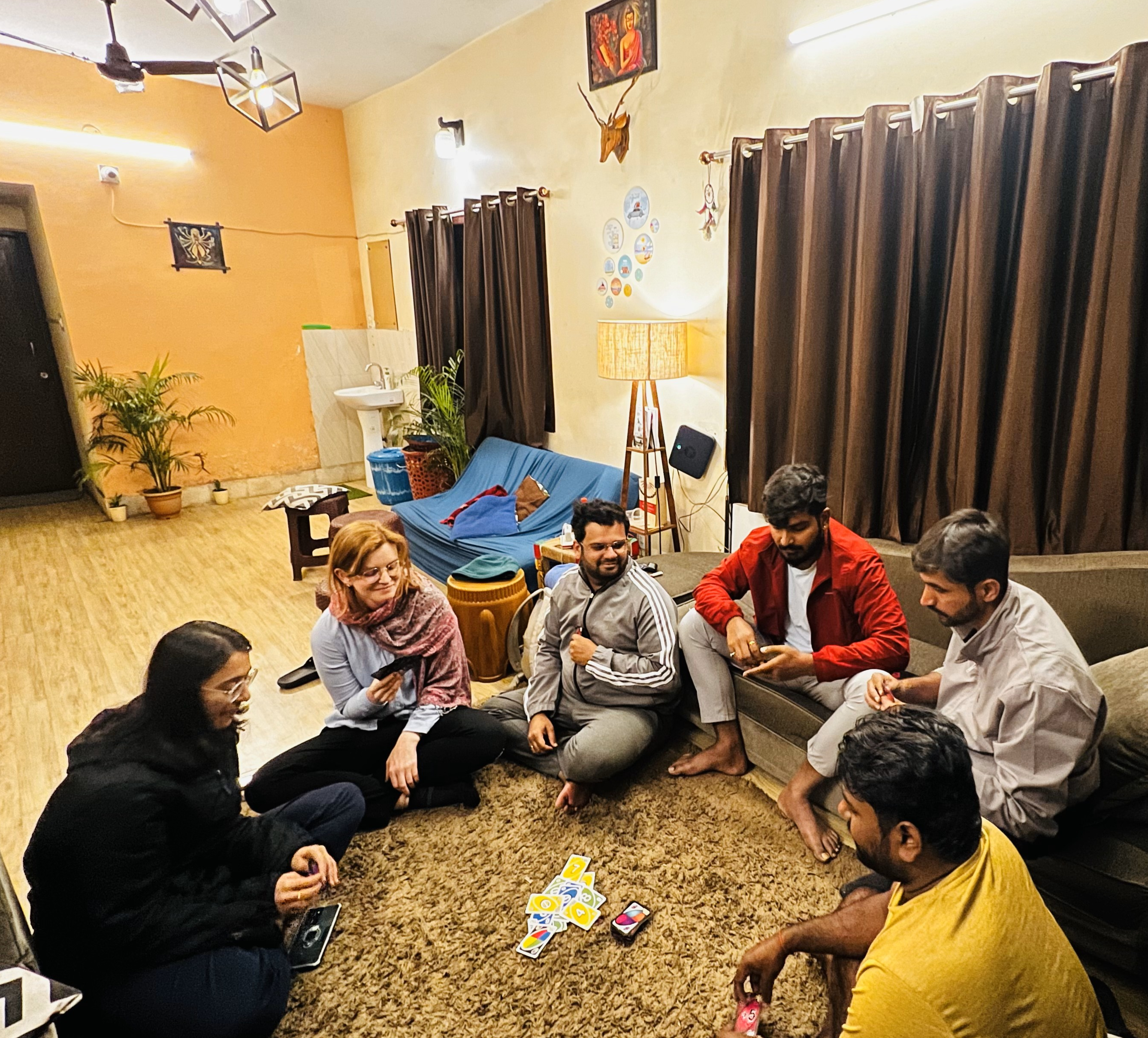 Guests playing card games and relaxing in the cozy ground floor lounge on comfortable rug