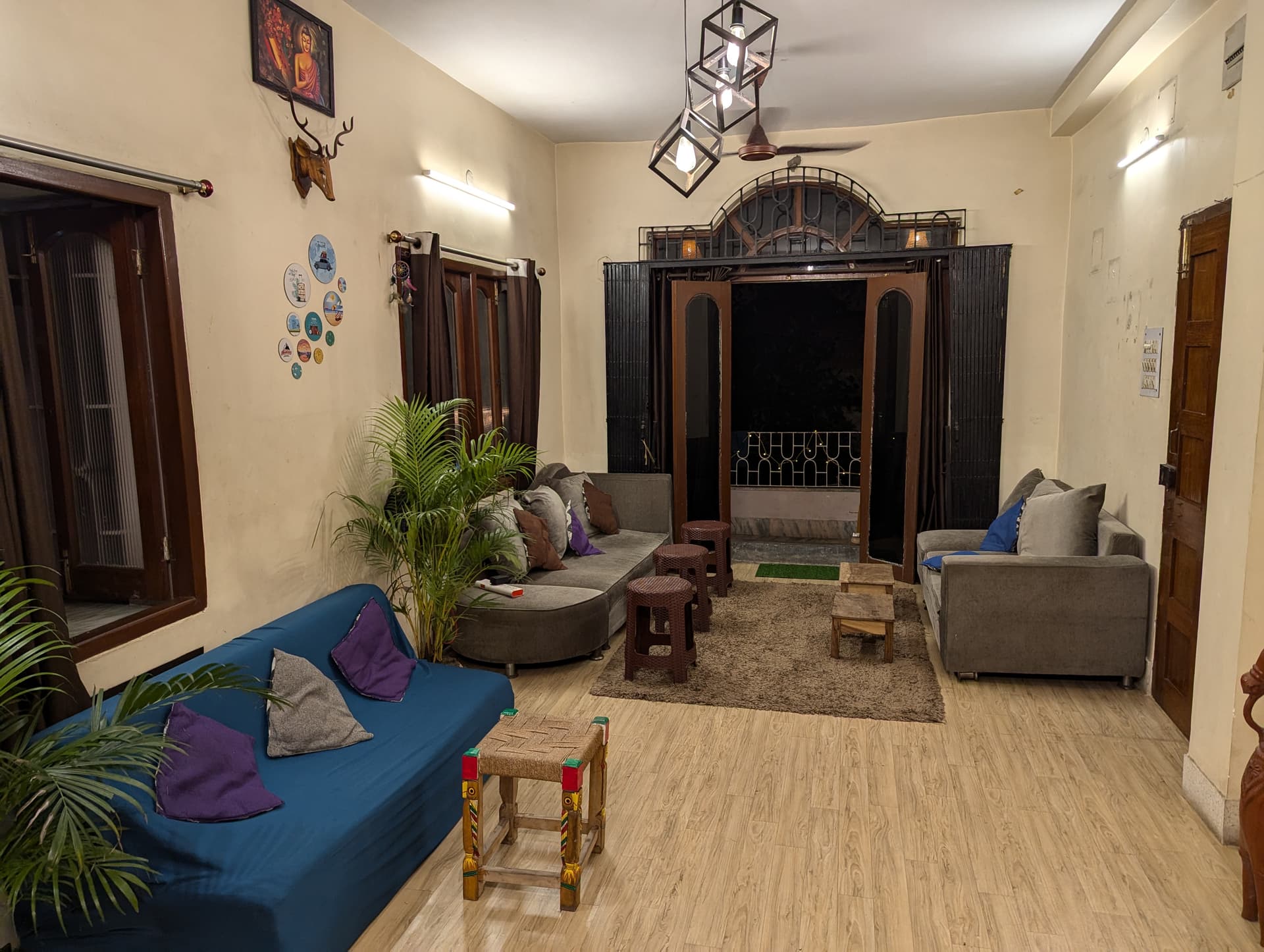 Guten Tag Kolkata main common lounge with plush sofas and balcony doors