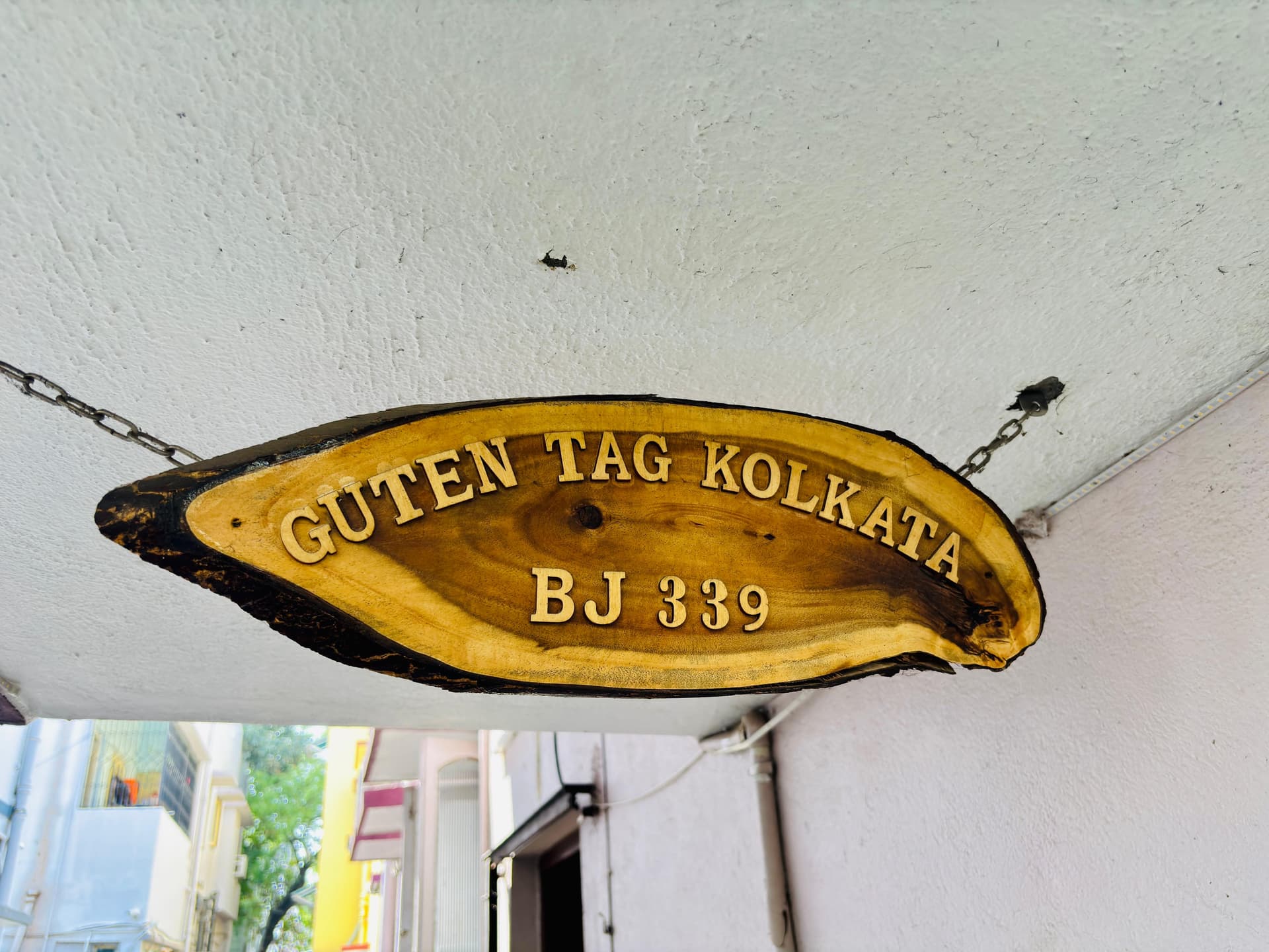 Wooden entrance signboard reading Guten Tag Kolkata BJ 339
